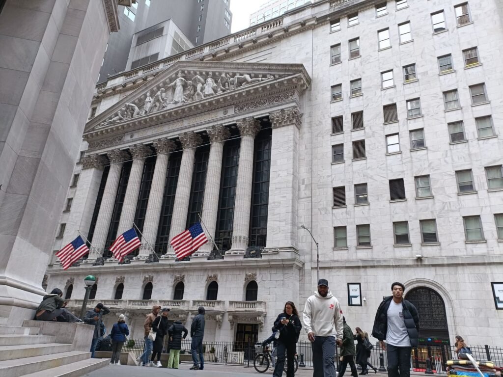 “Entrada principal de la Bolsa de Nueva York con inversores y banderas”