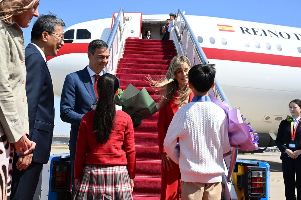 Pedro Sánchez y Begoña Gómez saludan durante su llegada en avión oficial en un viaje institucional